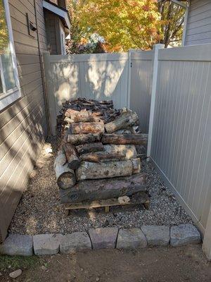 Groundcover, rocks and pallets for a tidy wood pile