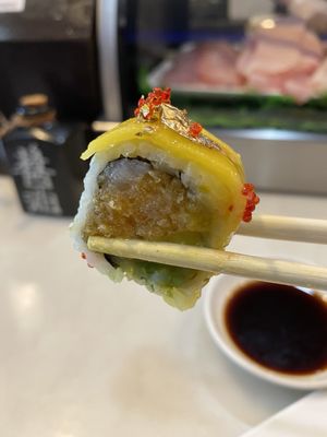 C.I.A Roll $15 Spicy yellowtail, avocado, mango & crunch, inside, mango on top with chef' special sauce, Tobiko & golden powder