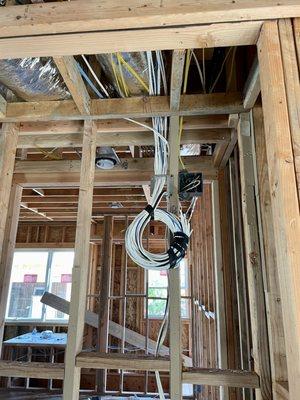 Pulling all CAT6 wires for data and cameras in closet room during framing stages for residential property.