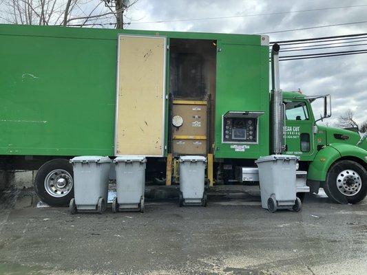 Eye catching, green paper shredding truck parked in front of the building