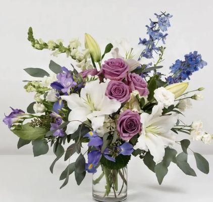 A customer favorite lavender roses white lilies and blue delphinium