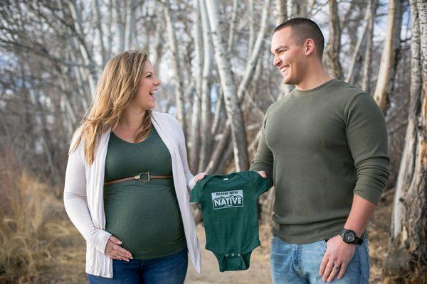 Pregnant momma to be laughing with dad to be during their maternity photo session in Littleton, CO.