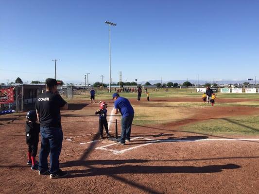 Ironbirds player getting ready to hit off the T, listening to instruction by his coach