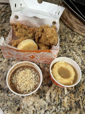 Four piece chicken, biscuit, dirty rice and mashed potatoes.