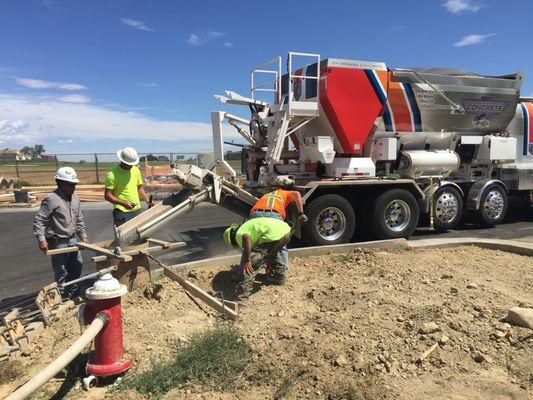 Laying concrete for light pulls in a new subdivision.