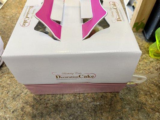 Carry out cake box with handles on top and they include a plastic cake cutter on the side of the box.