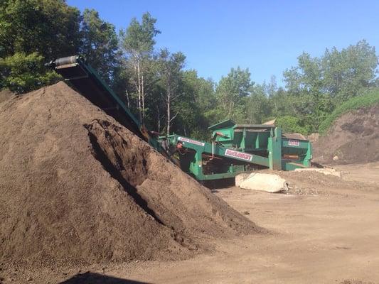 Loam pile and sifter in back