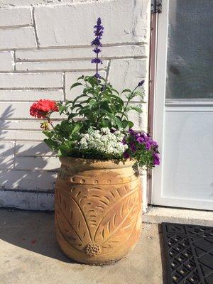 Container garden with purple salvia, geranium, purple calibrachoa and sweet allysium.