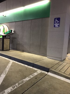 Handicap/Wheelchair ramp at end of narrow sidewalk.