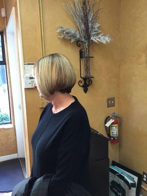 Short back with longer front. With root color and blonde highlights