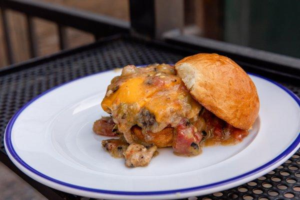 Slopper Sliders: Two open-faced Burgers with American Cheese, Smothered in Pueblo Green Chile, topped with Diced Onions.