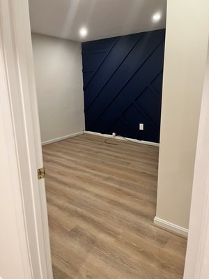 Added overhead lighting, removed carpet and replaced with LVP, built and painted accent wall for our gym.