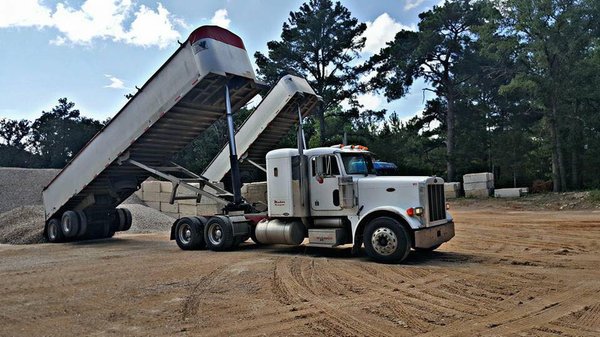 Truck # 110 unloading 3/8 pea gravel, and Truck # 903 unloading 1" Rock..