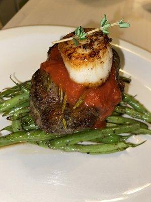 Leg a lamp steak top with scallop and Marinara sauce and sautéed green beans