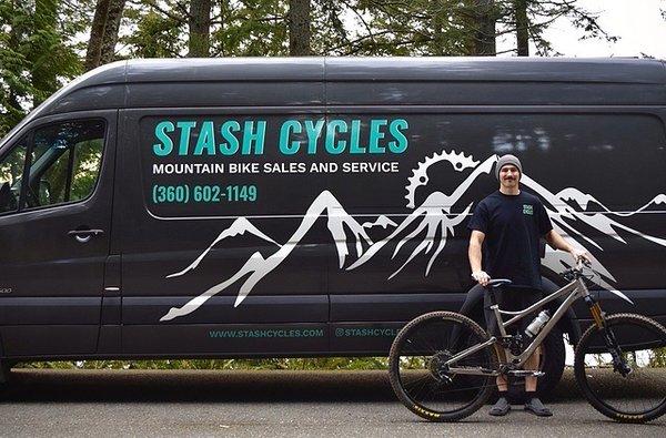 Mobile mountain bike sales and service van and owner with a bicycle.