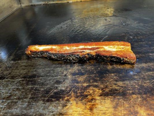 A slice of our bacon steak, slow cooked on the griddle.