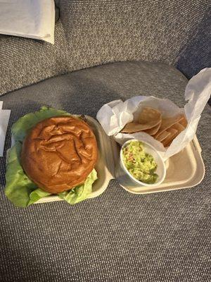 Chicken sandwich and chips with guacamole