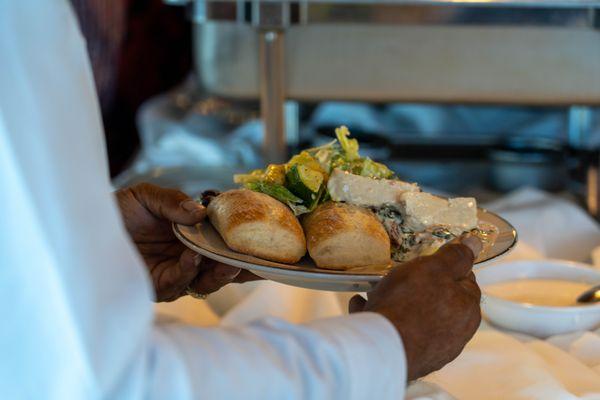 Tuscany chicken, caesar salad and dinner rolls and Photo by Ben Afrang Photography.