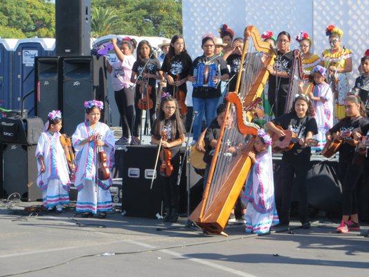 Children playing music during the community fair.