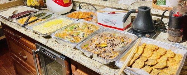 Tray of catered foods (L to R): rice, 2 kinds of namool, potato salad, unfermented kimchi, japchae, bulgogi, and 2 kinds of jeon