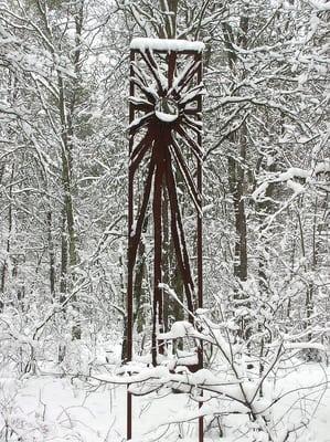 First Sun Studio logo scupture in the serene winter woods.