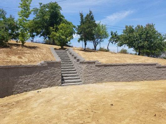 Beautifully graded, installed retaining wall and staircase in our backyard!