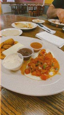 Slavadorian breakfast: tortillas, eggs (rancheros), plantain, refried salvadorian beans, cheese, and cream.  Desayuno del Dia