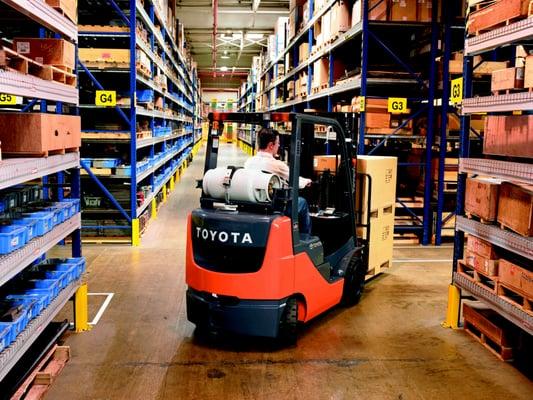 Toyota Forklift Model 8FGCU25 Driving Down the Aisle