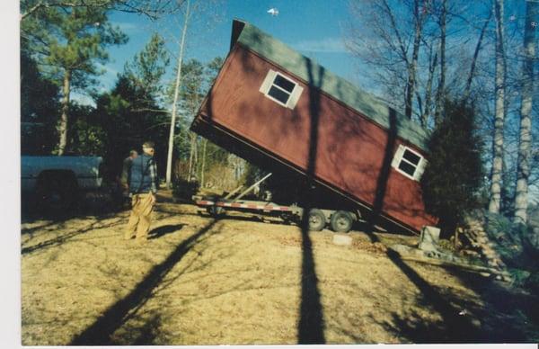 Red shed with dove gray shingles.  Being unloading at customers property.