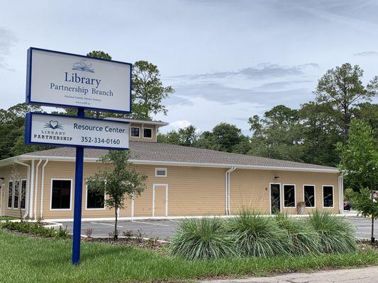 Photo overlooking exterior sign and building for Library Partnership Branch.