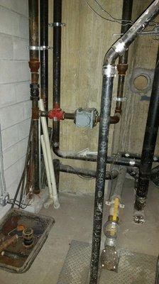 Gas meter room, gas meter install with sump pump and piping.