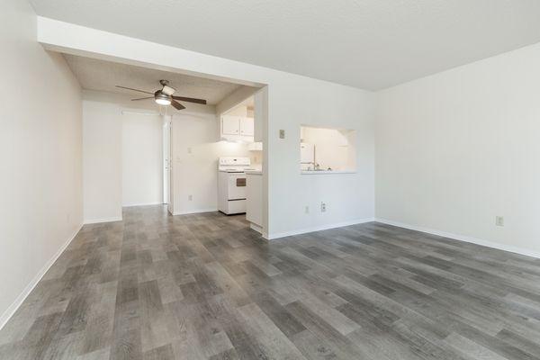 Experience seamless living in our stylish space! Grey wood flooring flows from living to dining to kitchen, accented by a cozy ceiling fan.