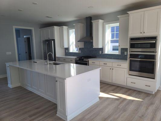 Another angle of a stunning kitchen with white cabinets and LVP.