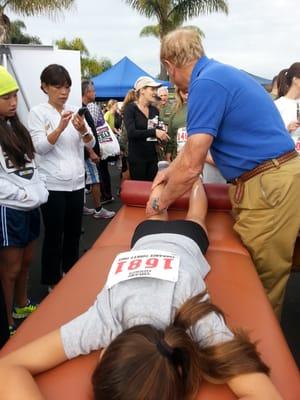 Dwight Davis, president of Atlantis, providing a Turkey Trot runner a much needed massage.