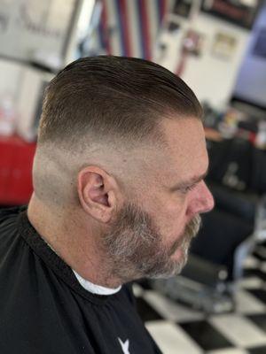 High fade with a slick back on top