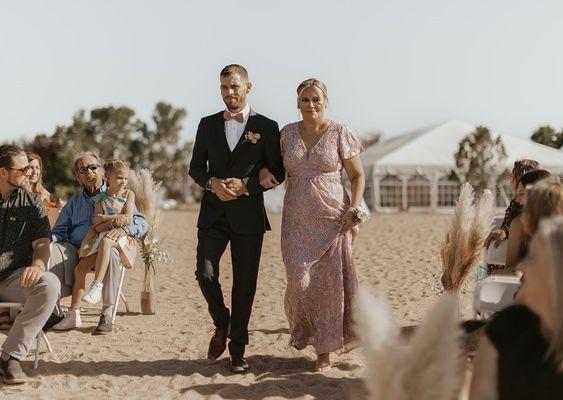 My son walking me down the aisle to be seated as mother of the bride in the dress Elizabeth fixed.