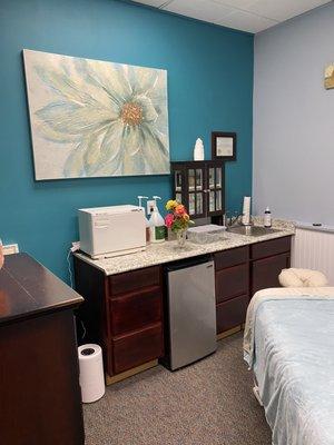 Treatment room with hot towel cabinet and fridge for cold bottled water