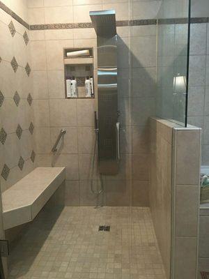 Custom shower with a floating bench and full body spray system