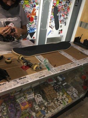 Getting my skateboard put together at zumiez w/ pricilla