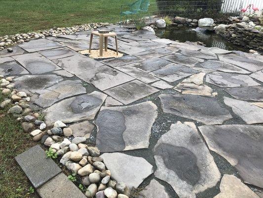 Flagstone patio next to a fish pond