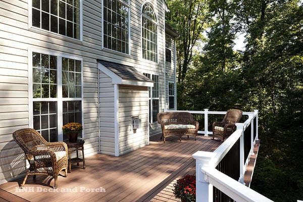 Vinyl deck using Wolf amberwood decking with rosewood border and Deckorators white PVC railing with black balusters.