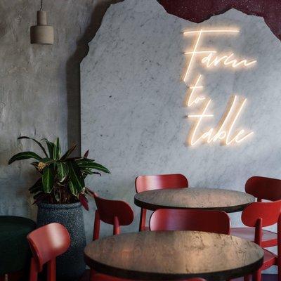 A modern and classic neon sign that says Farm to Table