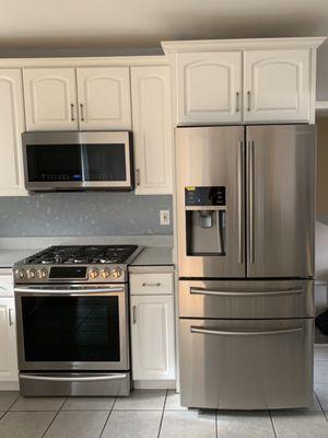 Newly installed microwave, gas stove, and water line for the fridge.