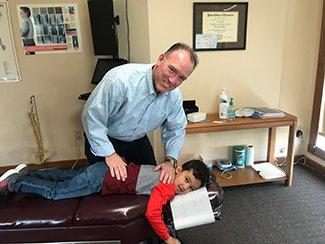 Dr. Patrick Maddigan adjusting a pediatric patient