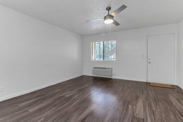 Living room with air conditioner and ceiling fan.