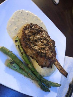 Pork chop with some ground mustard sauce, potatoes and asparagus