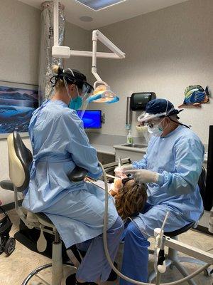 Doctor and assistant in PPE gear.