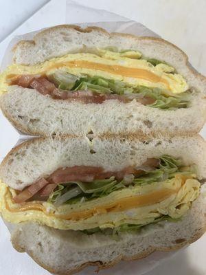 Eggs and cheese with lettuce and tomato breakfast sandwich