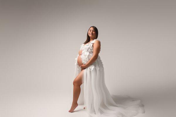 pregnant mama wearing a stunning white gown during her in-studio maternity session