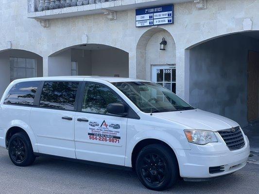 One of A+ Car Rentals adversiting vans in front of the office